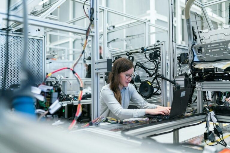 Ingenjör arbetar vid en laptop i en avancerad industrimiljö